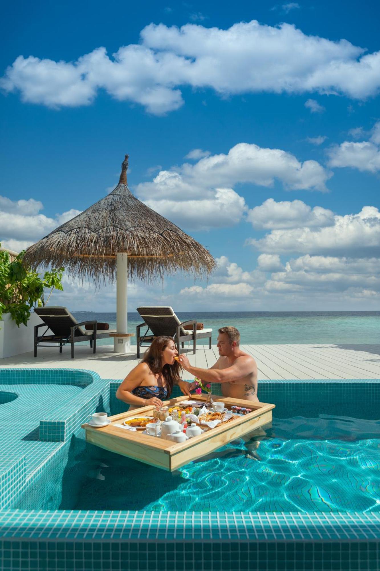 มลาฮินี กูดา บันดอส รีสอร์ต Hotel ฮุลฮูมาเล ภายนอก รูปภาพ A couple dining at the pool of a resort in Maldives